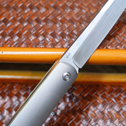 Production test Pocket knife with non-locking mechanism, titanium alloy handle, carbon fiber inlay, M390 hand-finished satin finish.